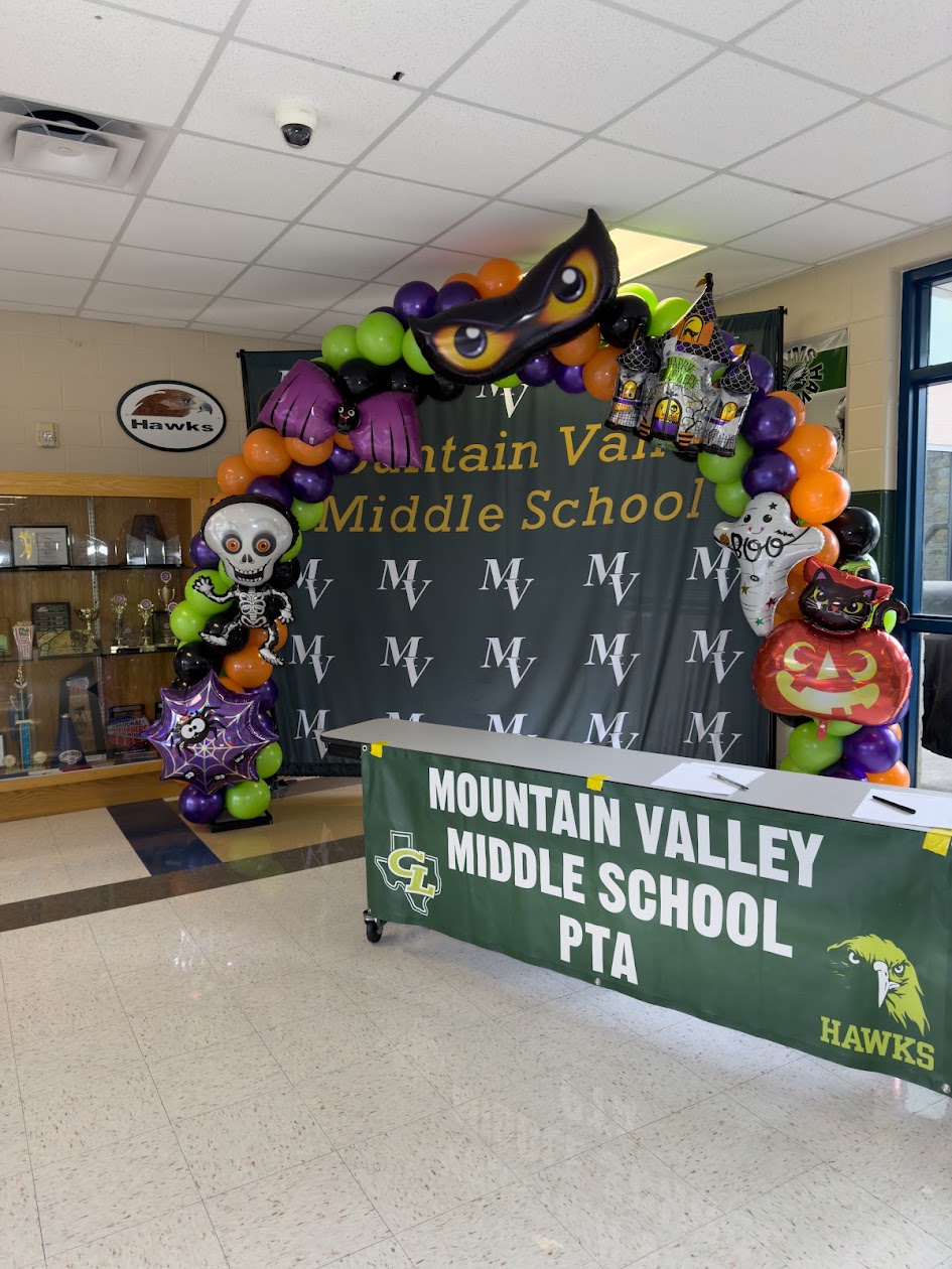 Halloween balloon arch framing a school event backdrop