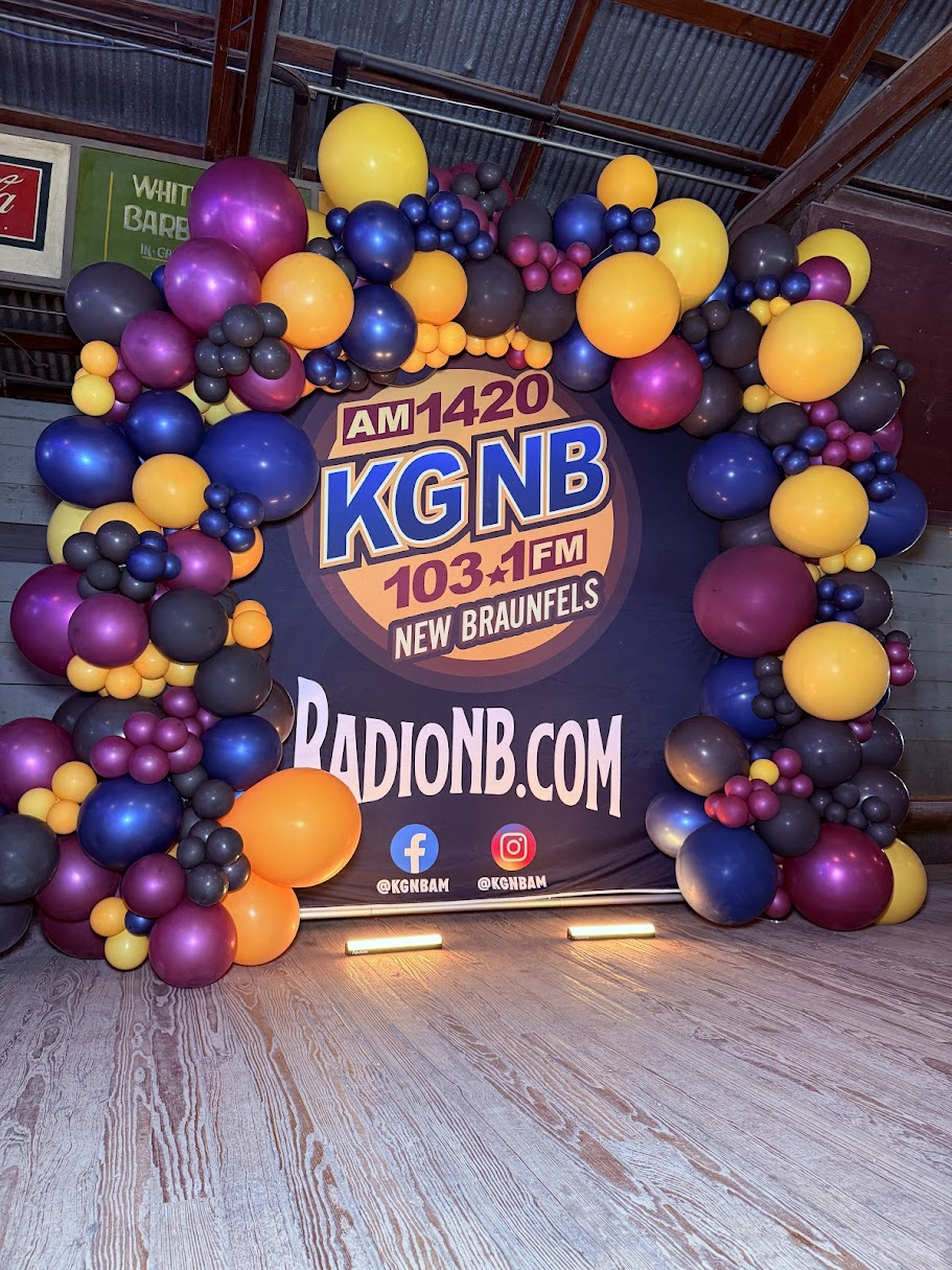 Purple orange and blue organic balloon display around a radio station backdrop